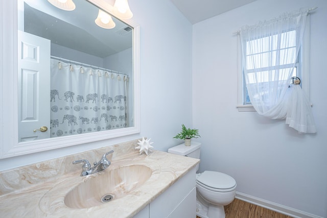 full bath with toilet, wood finished floors, vanity, visible vents, and baseboards