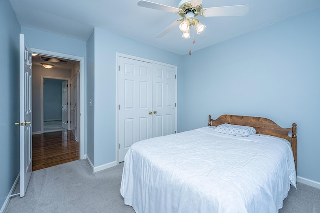 bedroom with a closet, light carpet, visible vents, and baseboards