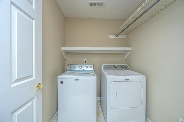 washroom featuring washer and dryer, laundry area, visible vents, and baseboards