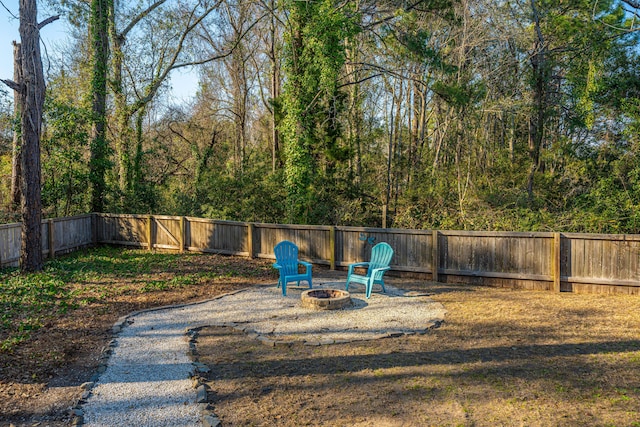 view of yard featuring a fenced backyard and a fire pit