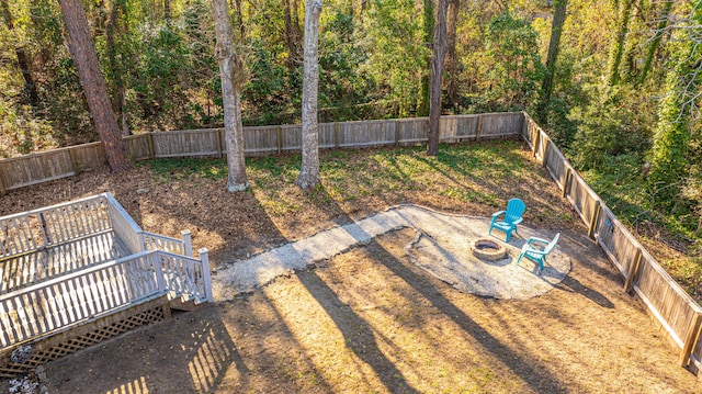 view of yard with a deck, an outdoor fire pit, and a fenced backyard