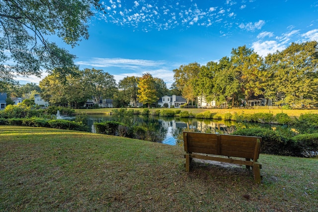 surrounding community featuring a water view and a lawn