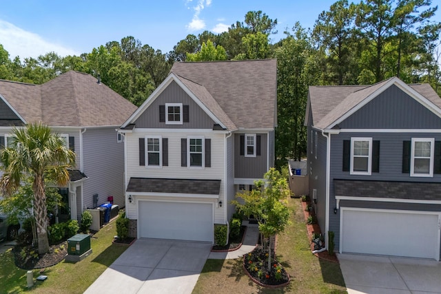 traditional-style home featuring concrete driveway, a front lawn, roof with shingles, and a garage