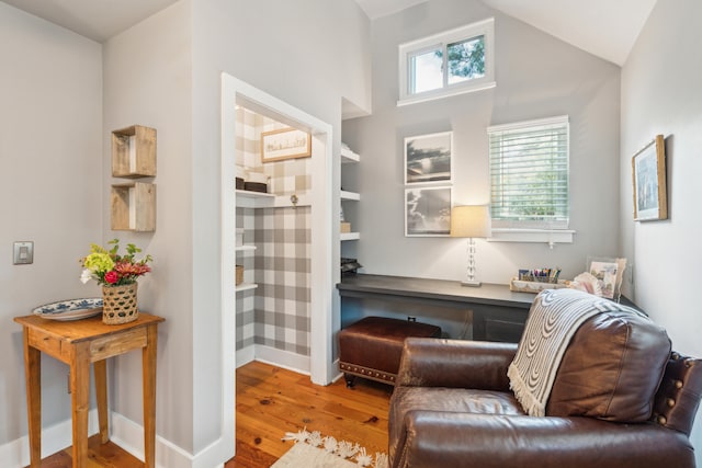 living area featuring vaulted ceiling and light hardwood / wood-style flooring