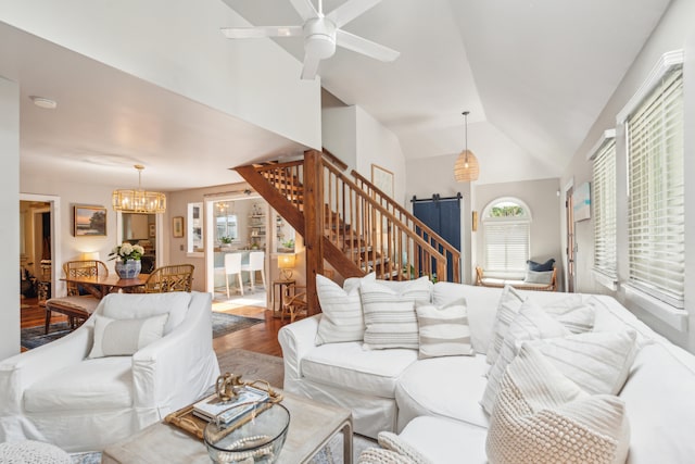 living room with wood-type flooring, ceiling fan with notable chandelier, and lofted ceiling