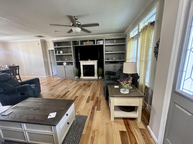 1173 Penny Creek Dr, Ruffin, SC 29475 - living area featuring light wood finished floors, crown molding, a ceiling fan, and a fireplace with raised hearth