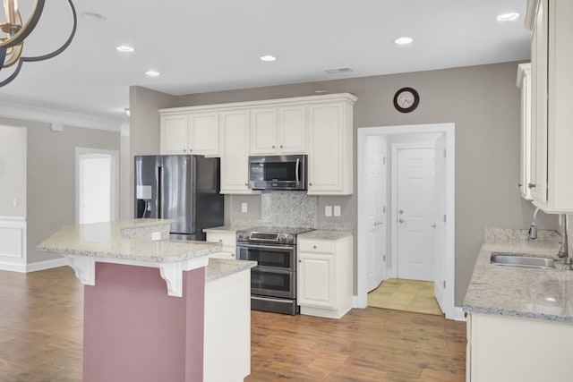 102 Brutus Ln, Summerville, SC 29485 - kitchen with a sink, a breakfast bar area, appliances with stainless steel finishes, a center island, and white cabinets