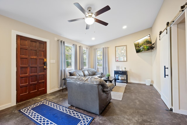 living room with a barn door, ceiling fan, and vaulted ceiling