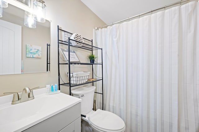 bathroom with walk in shower, vanity, lofted ceiling, and toilet