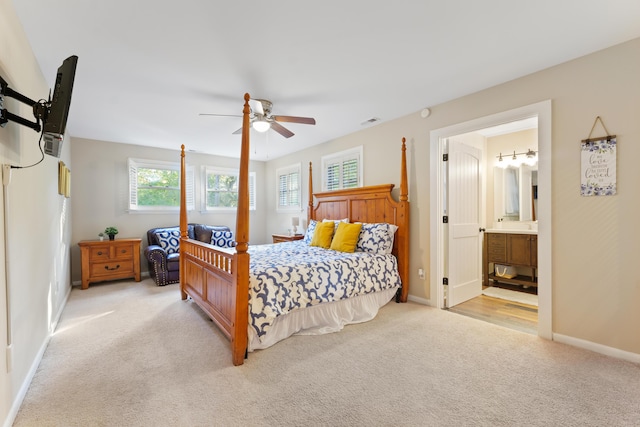 bedroom featuring ceiling fan, light carpet, and connected bathroom