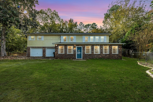 view of front of house featuring a garage and a lawn