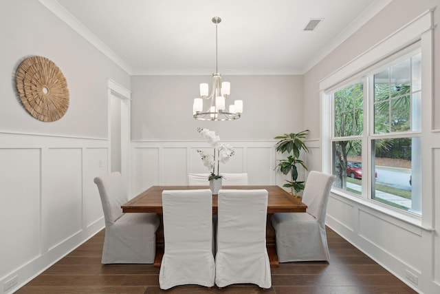 dining room with dark hardwood / wood-style floors, an inviting chandelier, and ornamental molding