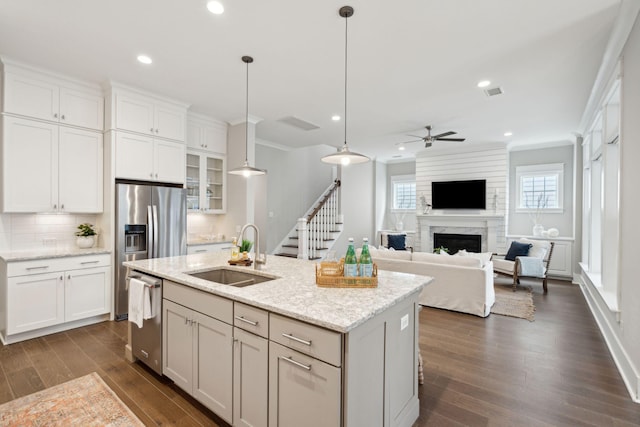 kitchen with white cabinetry, sink, ceiling fan, stainless steel appliances, and a high end fireplace