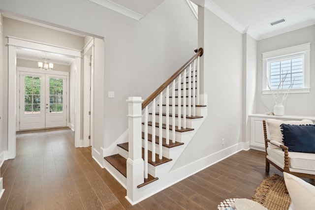 staircase with a chandelier, crown molding, french doors, and wood-type flooring