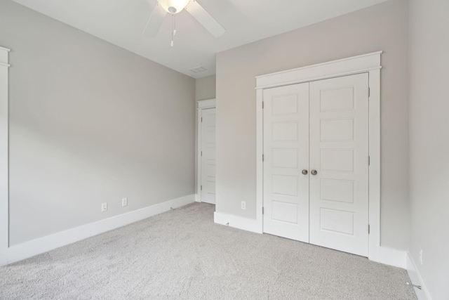 unfurnished bedroom with ceiling fan, a closet, and light colored carpet