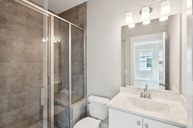 bathroom featuring vanity, an enclosed shower, and toilet