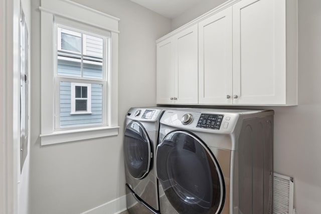 laundry area with washer and dryer and cabinets