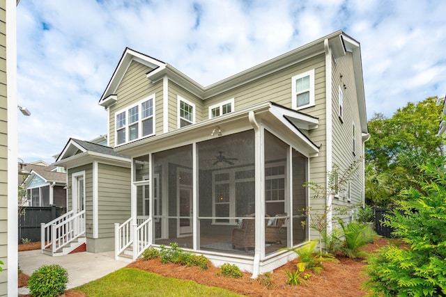 rear view of house featuring a sunroom