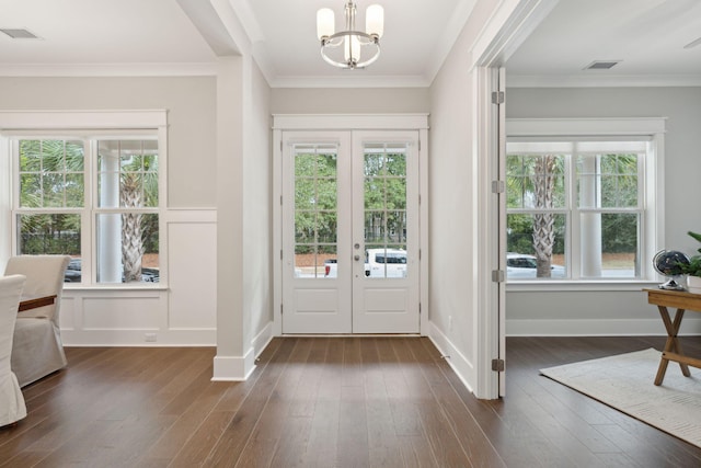 doorway to outside featuring a notable chandelier, dark hardwood / wood-style flooring, crown molding, and french doors