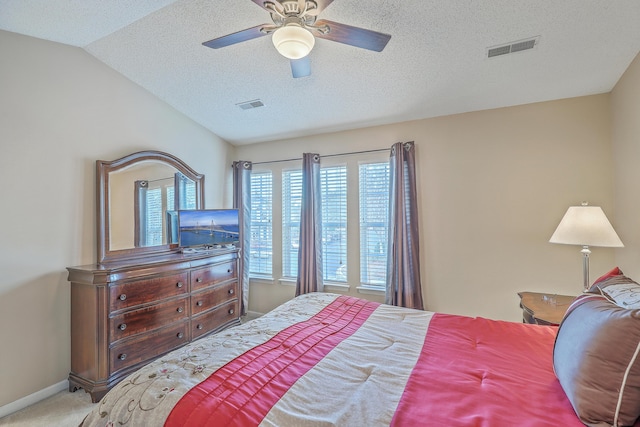 carpeted bedroom with vaulted ceiling, a textured ceiling, visible vents, and baseboards