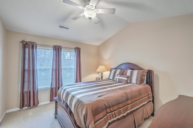 bedroom with visible vents, vaulted ceiling, a textured ceiling, and light colored carpet