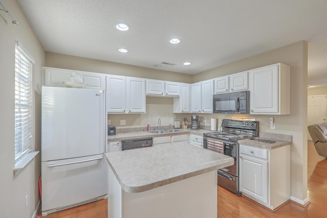 kitchen with white cabinets, light wood-style floors, a center island, light countertops, and black appliances