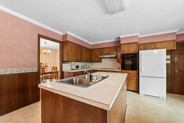 kitchen with oven, sink, ornamental molding, white fridge, and a center island with sink