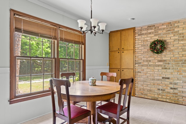 2266 Griffith Dr, Orangeburg, SC 29118 - dining space featuring a wainscoted wall, a wealth of natural light, brick wall, and a notable chandelier