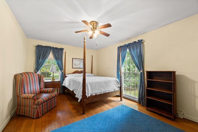 bedroom with hardwood / wood-style flooring, multiple windows, and ceiling fan