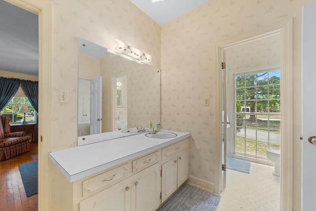 bathroom with hardwood / wood-style flooring, toilet, and vanity