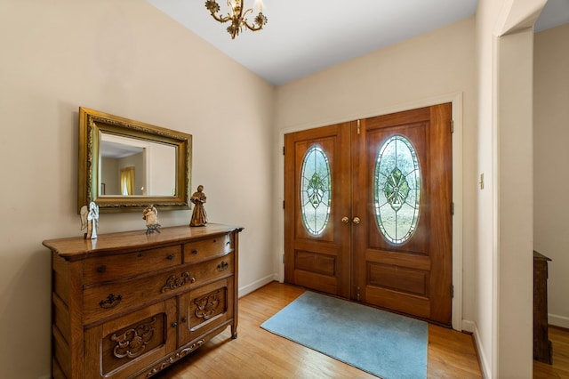 foyer entrance featuring light hardwood / wood-style floors and a chandelier