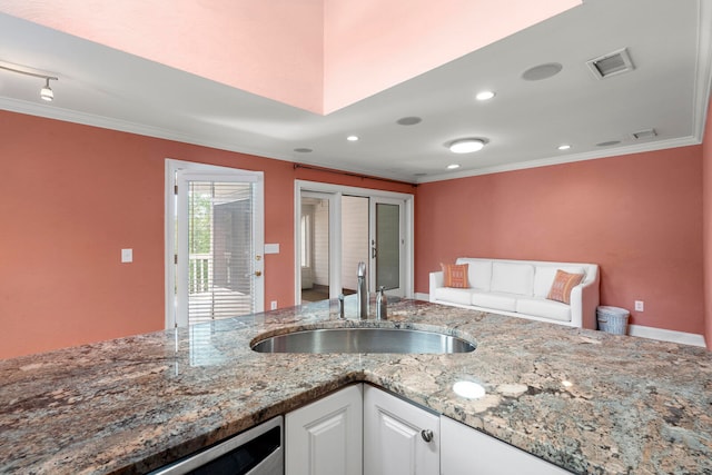 kitchen with white cabinetry, sink, ornamental molding, and light stone countertops