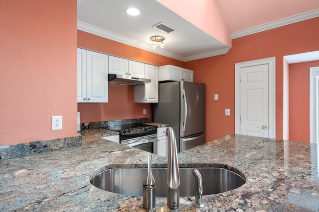 kitchen with white cabinetry, appliances with stainless steel finishes, ornamental molding, and dark stone counters