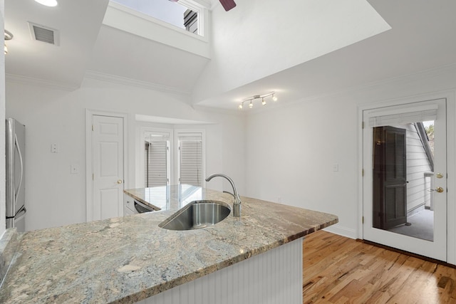 unfurnished living room featuring a sink, light wood-style flooring, ornamental molding, visible vents, and recessed lighting