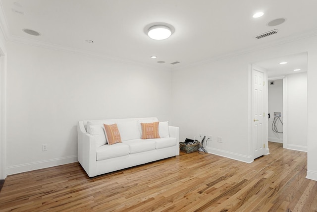 unfurnished living room featuring baseboards, ornamental molding, and light wood-style floors