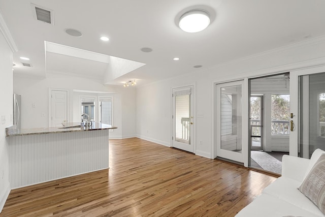 unfurnished room with light wood-style flooring, a ceiling fan, and baseboards
