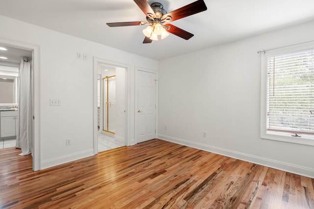 unfurnished bedroom featuring ceiling fan, light wood-type flooring, and ensuite bath