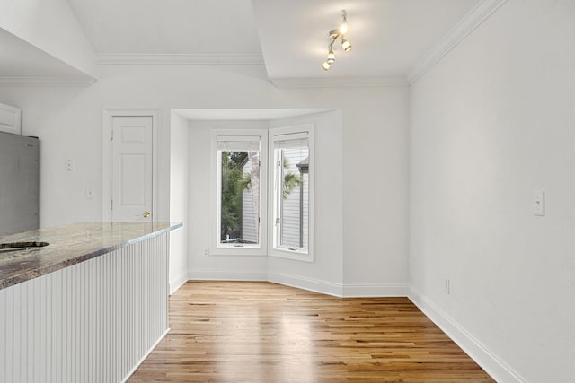 unfurnished bedroom with ensuite bath, light wood finished floors, baseboards, and ceiling fan