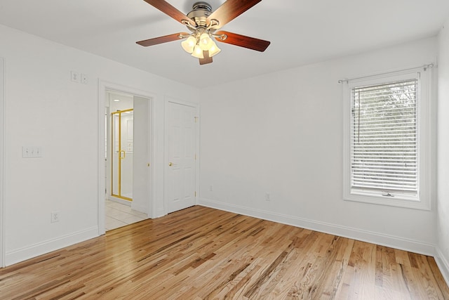 empty room with light wood-type flooring, visible vents, a ceiling fan, and baseboards