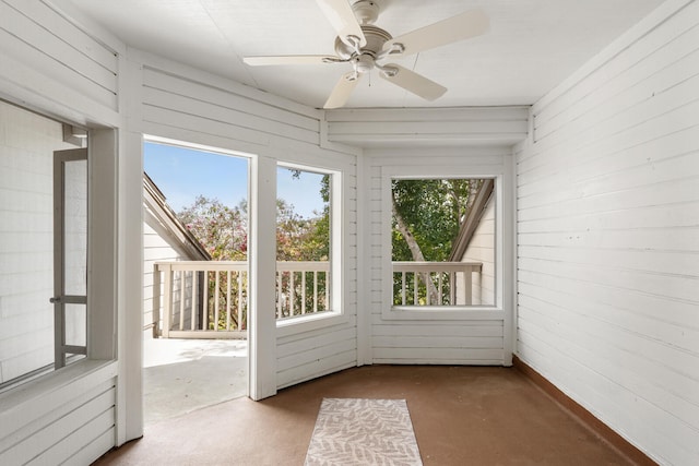 unfurnished sunroom featuring ceiling fan