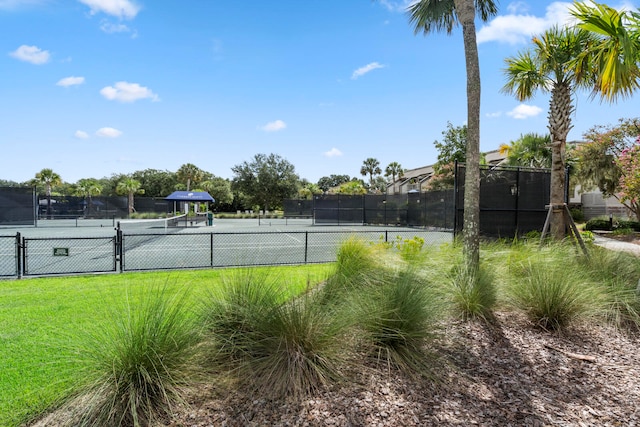 view of tennis court featuring a lawn