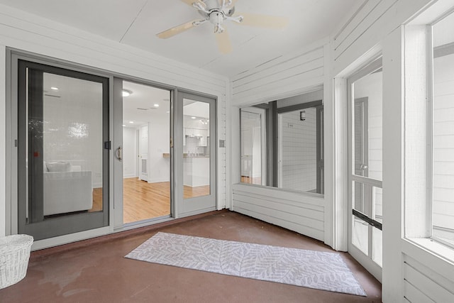 unfurnished sunroom featuring ceiling fan