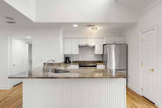 kitchen with freestanding refrigerator, light wood-style flooring, visible vents, and crown molding