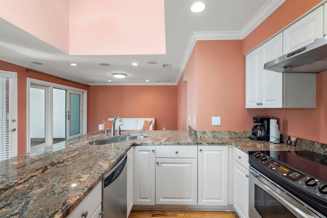 kitchen with stainless steel appliances, kitchen peninsula, and white cabinets