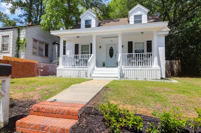 view of front of house featuring covered porch and a front yard