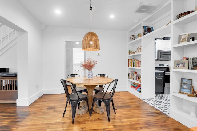 dining area with light wood-type flooring, baseboards, built in features, and recessed lighting