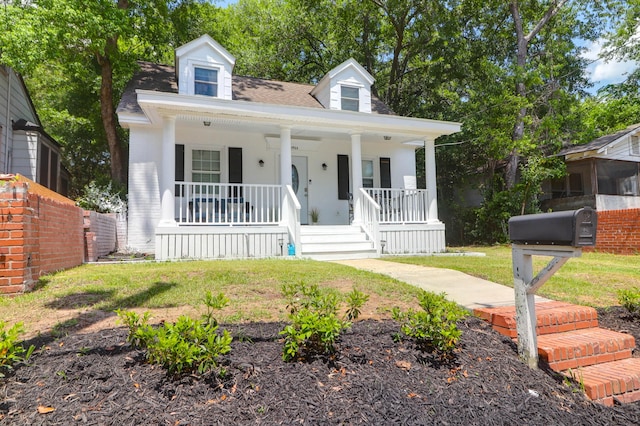 cape cod-style house featuring a porch and a front yard