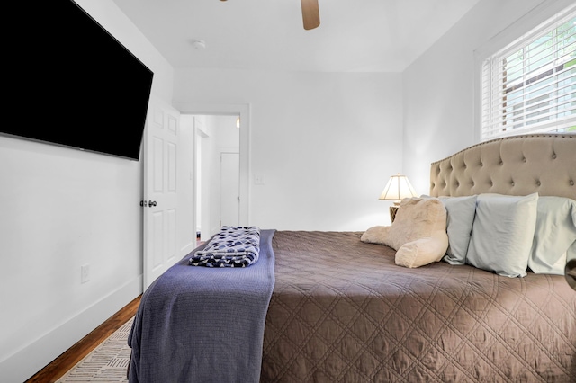 bedroom featuring wood finished floors, baseboards, and ceiling fan