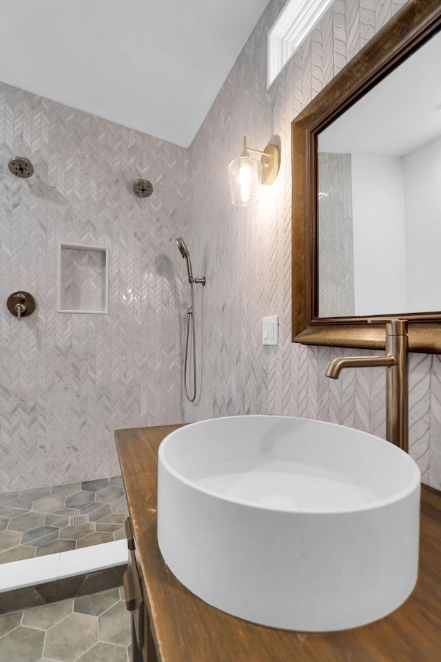 bathroom featuring a tile shower and vanity