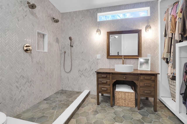 full bath with a tile shower, tile patterned flooring, and vanity